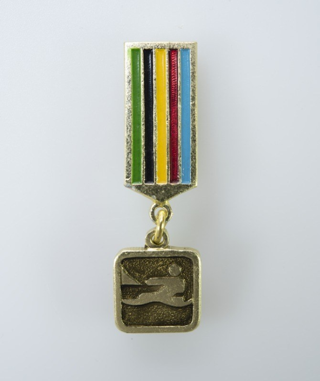 Goldmedaille mit einem farbigen Streifen, wahrscheinlich ein Schwimmmedaillie, vor einem weißen Hintergrund.