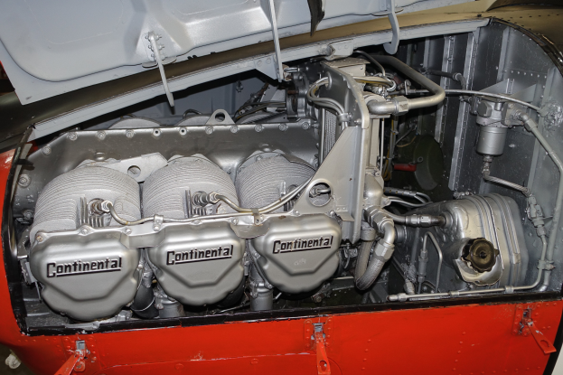 Nahaufnahme eines Automotors in einer Garage, der den Motorblock, Kolben, Ventile und andere Komponenten zeigt.