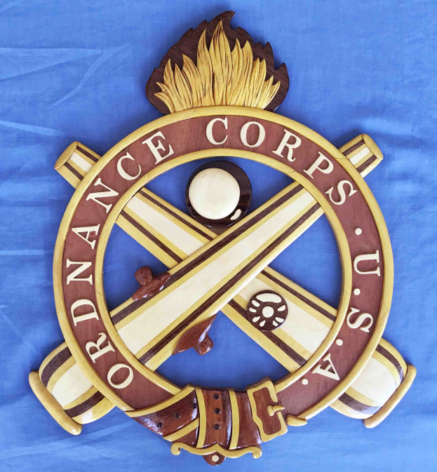 Holzschild mit "Ordnance Corps"-Text, verziert mit einem geschnitzten weißen Stern auf einem navy-Hintergrund mit goldener Umrandung, auf blauem Tuch montiert.