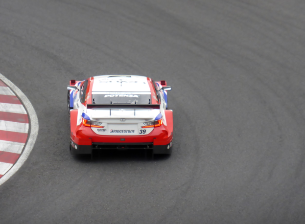 Rotes und weißes Toyota Supra GT3-Sportwagen auf einer Rennstrecke, mit dem Text "Toyota Supra GT3" auf der Seite.