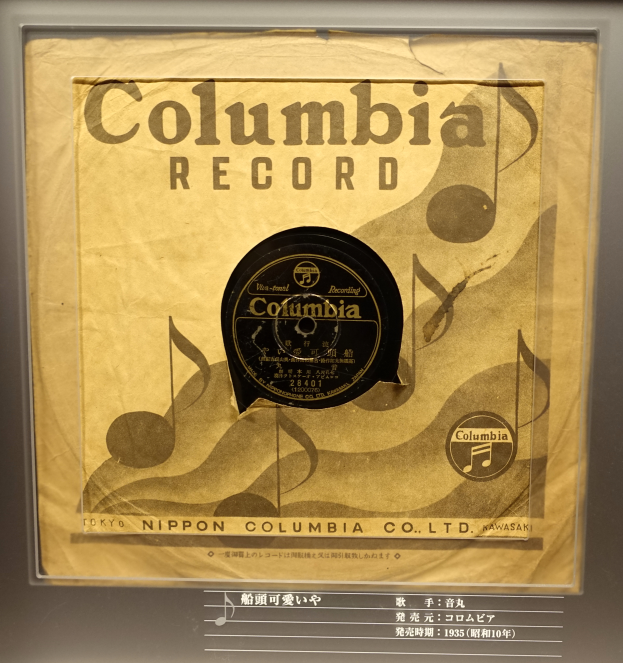 Eine alte Columbia-Schallplatte in einer Glasvitrine mit einem beschrifteten Rahmen.