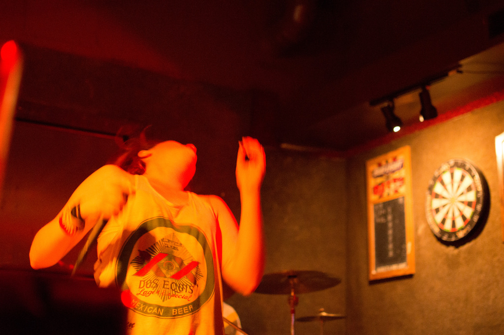 Eine Person in einem Oberteil tanzt mit sichtbaren Lichtern auf der rechten Seite.