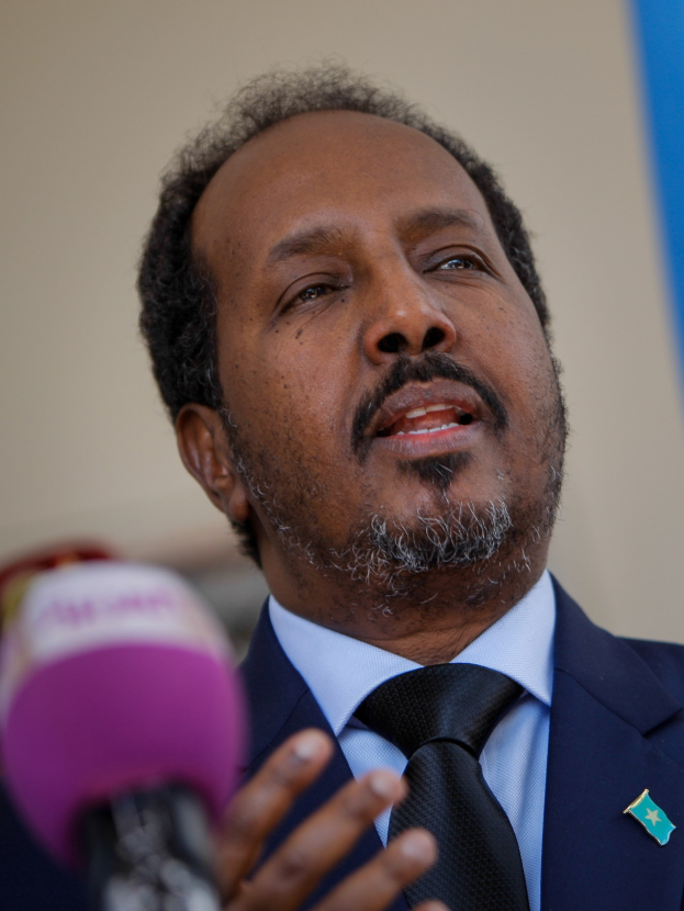 Ein Mann in Anzug und Krawatte spricht in ein Mikrofon, wahrscheinlich zu einem Publikum als Politologe.