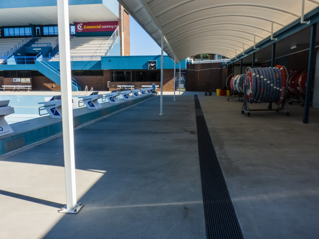 Großer Hallenbad mit zahlreichen Stühlen, einem Gebäude, Treppen, Geländern und Texttafeln im Hintergrund an der University of Texas at Austin.