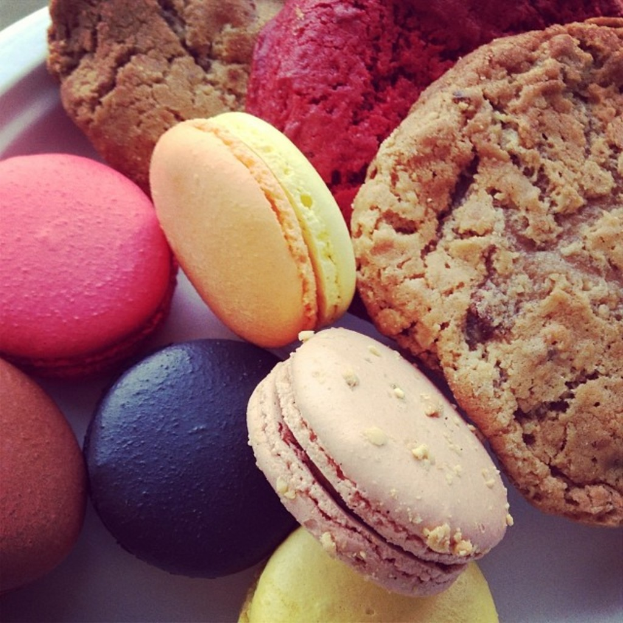 Verschiedene Macarons und andere Lebensmittel nebeneinander angeordnet.