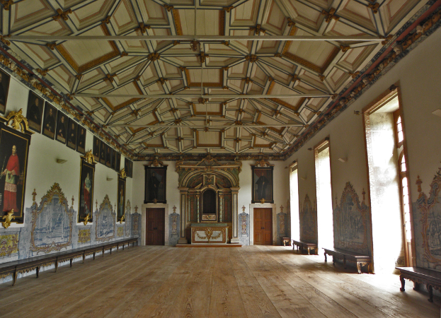 Ein Innenblick auf einen Saal mit Rahmen, Kunst, Türen, Fenstern und Bänken an den Wänden.