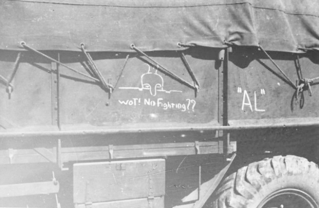 Schwarz-weiß-Foto eines Trucks mit Graffiti an der Seite, das vier Räder und einen Reifen zeigt.