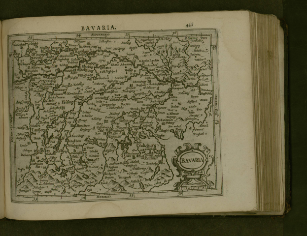 Ein aufgeschlagenes Buch mit einer detaillierten Karte von Bayern, auf der Städte und Ortschaften beschriftet sind, begleitet von erläuterndem Text.