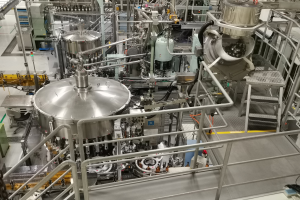 Ein großes Reaktormaschinengehäuse in einem Gebäude mit einem Boden, Geländern, Treppen und diversen umliegenden Komponenten und Maschinen.