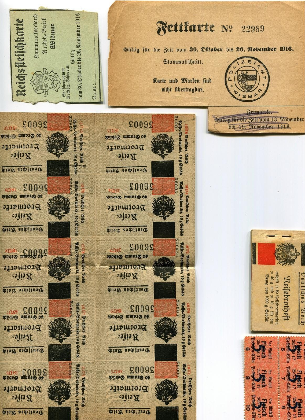 Sammlung von abgenutzten, alten deutschen Tickets und Marken auf einem weißen Hintergrund, einige mit gedrucktem Text und Zahlen.