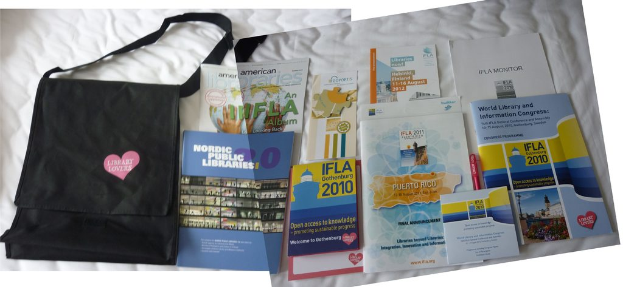 Eine Tasche mit 'Bibliotheksliebhaber' drauf und einige Bücher liegen auf einem Bett.