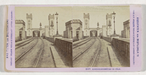 Schwarz-weiß-Stereoskopiebild einer Eisenbahnbrücke in Köln, Deutschland, mit Eisenbahnschienen, Wänden, Pfählen, Statuen, Himmel und Text.