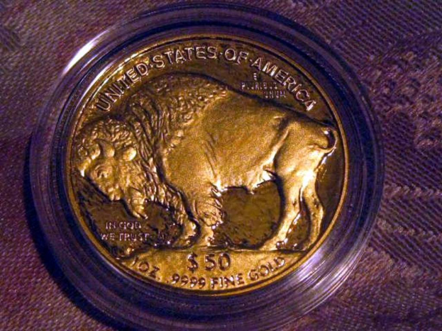 Eine goldene und braune Münze mit der Aufschrift "The United States Of America" darauf, auf einer braunen Teppichfläche platziert.