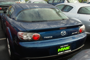 Mehrere Autos stehen auf einem Parkplatz mit einem Schild unten im Bild.