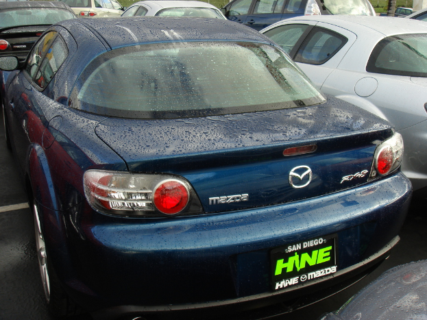 Mehrere Autos stehen auf einem Parkplatz mit einem Schild unten im Bild.