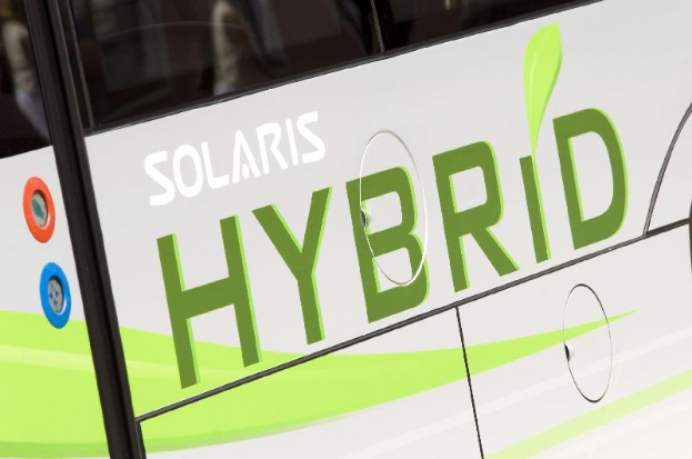 Ein Nahaufnahme eines weißen und grünen Busses mit der Aufschrift "Solaris Hybrid", der ein Elektrofahrzeug anzeigt.