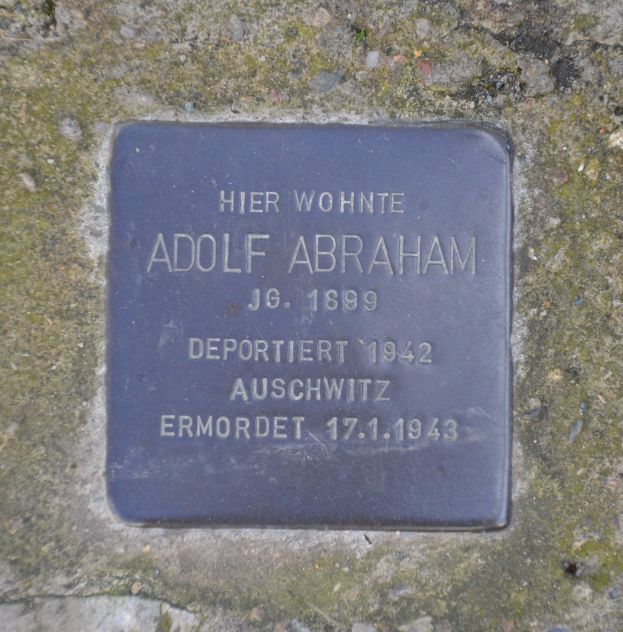 Plakette an einer Steinwand mit der Inschrift "Adolf Abraham".