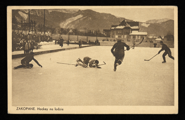 Ein altes Schwarz-Weiß-Foto von Menschen, die Hockey auf einem Eisring spielen, umgeben von Gebäuden, Bäumen, Pfählen und Bergen im Hintergrund, mit Text am unteren Rand des Bildes.