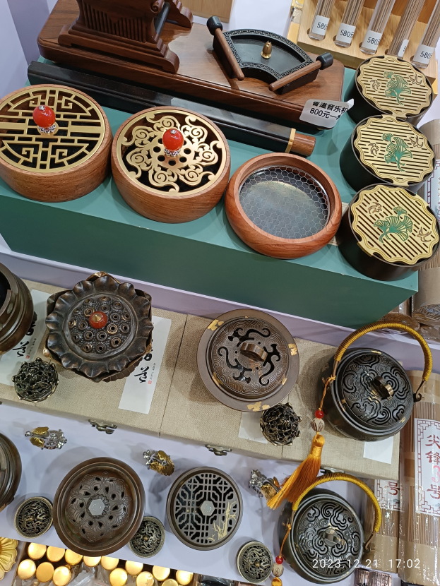 Verschiedene chinesische Räucherstäbchenbrenner, Schachteln und Papiere mit Text darauf, die auf einem Tisch arrangiert sind, wahrscheinlich für ein chinesisches Neujahrsfest.