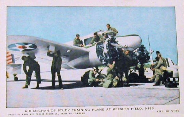 Gruppe von Menschen um ein Trainingsflugzeug auf einer Landebahn mit einem klaren blauen Himmel, Text unten lautet "Luftmechanikerstudium Training Flugzeug am Keesler Field, Miss."