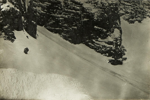 Eine Person, die eine schneebedeckte Bergabfahrt hinabfährt, umgeben von schneebedeckten Hügeln, mit Text am unteren Bildrand.