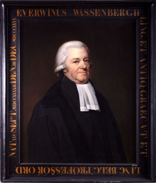 Portrait eines Mannes in einer schwarzen Robe, eingerahmt mit Text, der darauf hinweist, dass er möglicherweise ein Anwalt ist, der mit gefalteten Händen und ernstem Gesichtsausdruck sitzt.