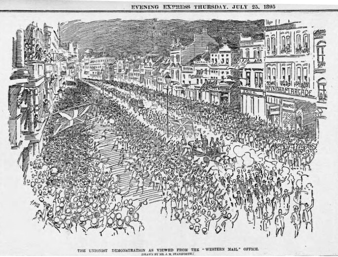 Schwarze und weiße Zeichnung einer Menge, die eine Straße zwischen Gebäuden entlanggeht, mit Text oben und unten: "Die Unionistendemonstration, wie sie vom Western Mail Office aus gesehen wird."